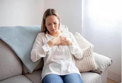 Femme se tenant la poitrine à cause d'une douleur dû à hypertension. ledegoteur.fr